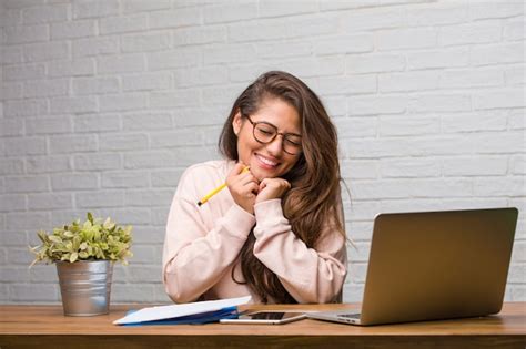 Retrato De Joven Estudiante Mujer Latina Sentada En Su Escritorio Muy Feliz Y Emocionada Foto