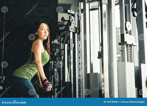 Asian Girl Exercising At Gym Training On Pushdown Cable Machine With Copy Space Healthy