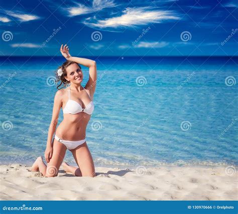 Mujer Sensual En El Bikini Blanco Que Se Sienta En La Playa Foto De