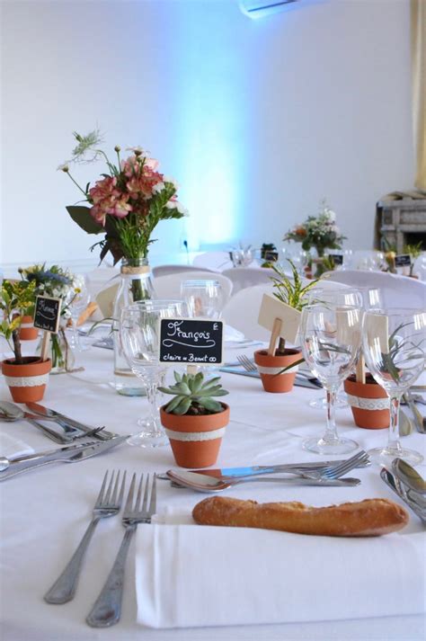 The Table Is Set With Silverware Wine Glasses And Succulents In Flower