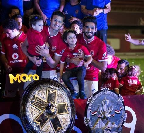 A Group Of Soccer Players Posing For A Photo With Their Trophy And Fans