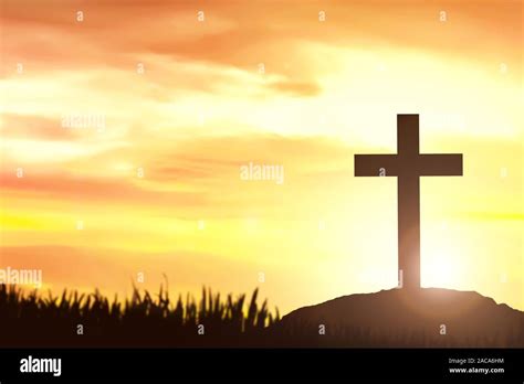 Christian Cross On The Field With A Sunset Sky Background Stock Photo