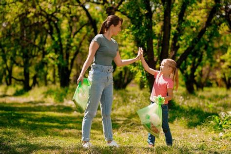 Linda Familia Recogiendo Basura En El Parque Foto Premium