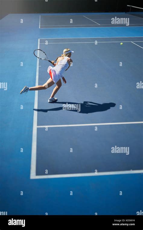 Young Female Tennis Player Playing Tennis Swinging Tennis Racket On