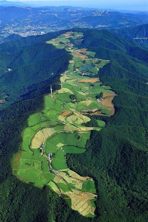 an aerial view of a golf course in the middle of green hills and ...