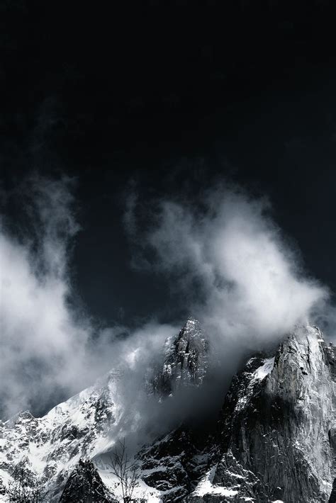 The Mountain Is Covered In Snow And Clouds