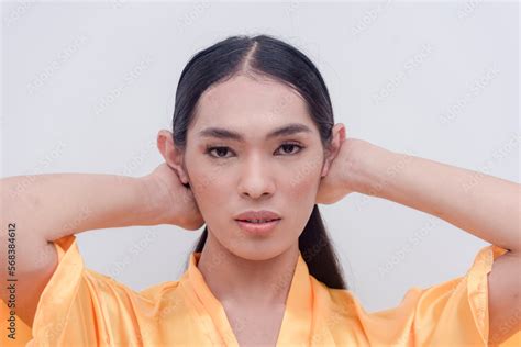 A Southeast Asian Transwoman Poses For The Camera While Tying Her Long Black Hair Showing Off