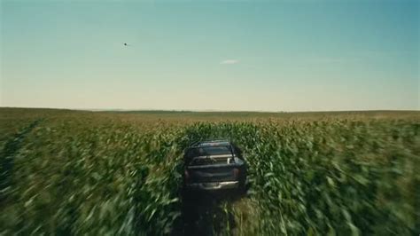 A Car Driving Through A Field Of Tall Grass