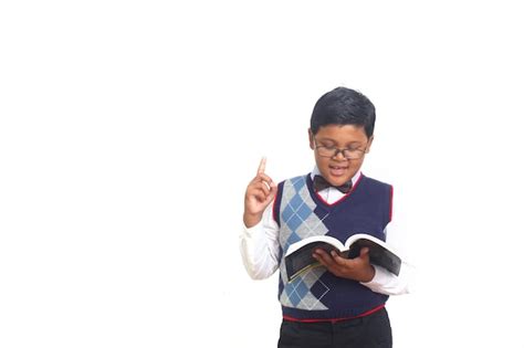 Menino Asi Tico Lendo Um Livro Contra O Fundo Branco Foto Premium