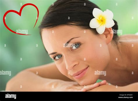 Composite Image Of Beautiful Brunette Relaxing On Massage Table Smiling At Camera Stock Photo