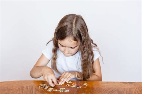 A menina recolhe peças para fazer uma imagem quebra cabeças