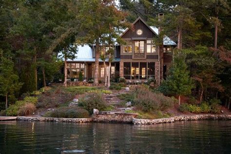 A Large House Sitting On Top Of A Lake Surrounded By Trees