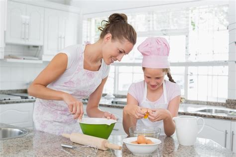 Premium Photo Girl Helping Her Mother Prepare Food In Kitchen