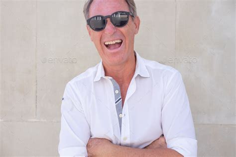 Portrait Of Happy Middle Aged Man Crossed Arms Laughing Looking At