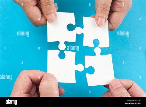 Two Hands Holding Jigsaw Puzzle Pieces And Putting Them Together Stock