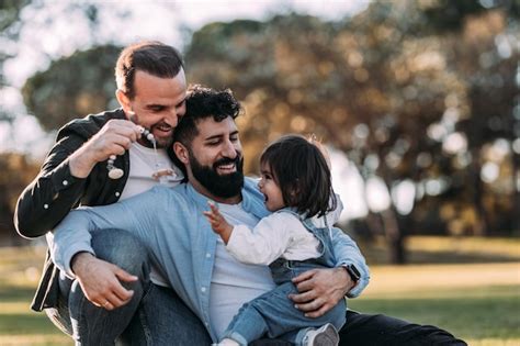 Famille Gay Masculine Treignant Et Jouant Avec Leur Petite Fille Dans Le Parc Photo Premium