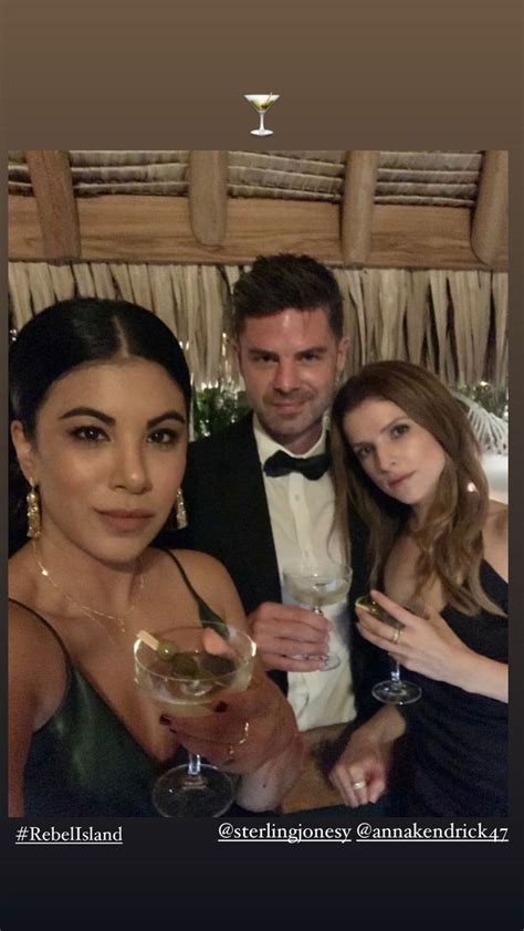 Two Women And A Man Posing For A Photo With Wine Glasses In Front Of Them