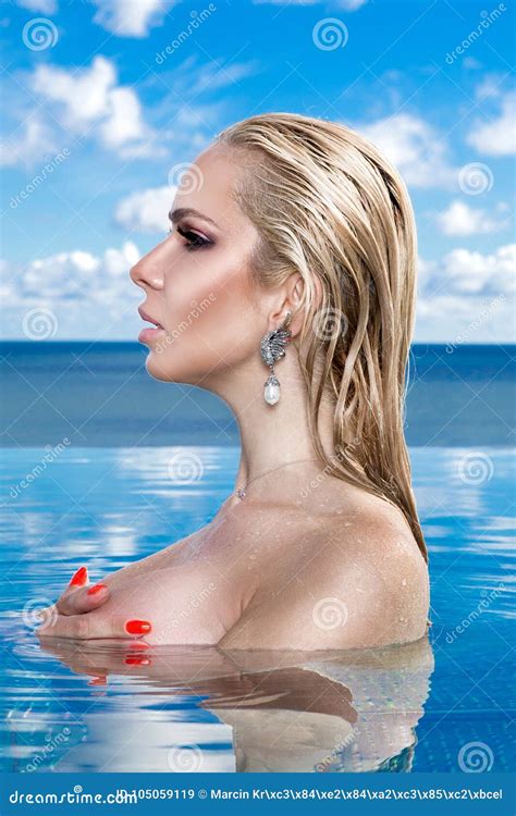 Beautiful Blonde Woman Model With Wet Hair And Elegant Makeup Sitting In A Pool Stock Image