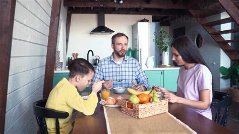 Familia Sentada A La Mesa Tomando Un Desayuno Saludable Stock Photo