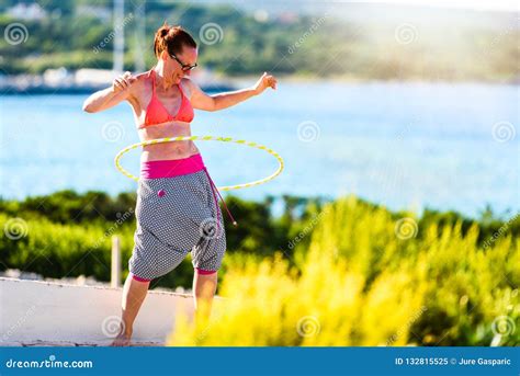 Attractive Adult Woman Is Playing With Hula Hoop In Nature Stock Image