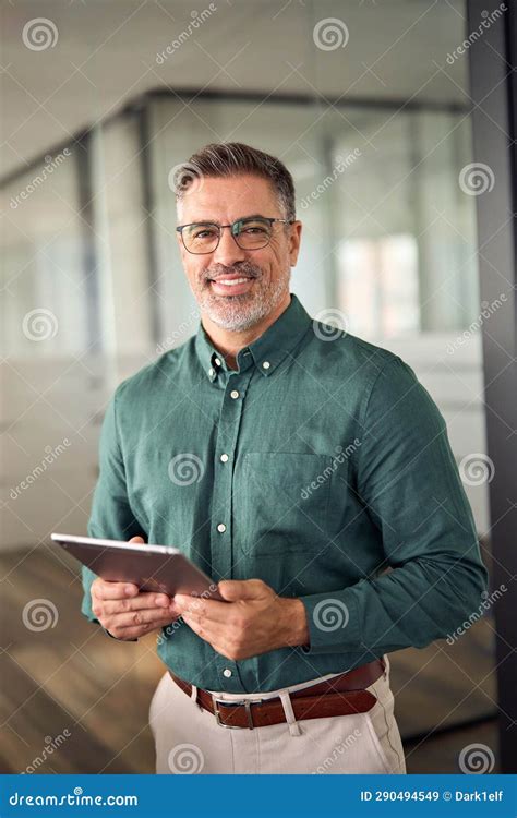 Senior Smiling Businessman Holding Tablet Standing In Office Vertical