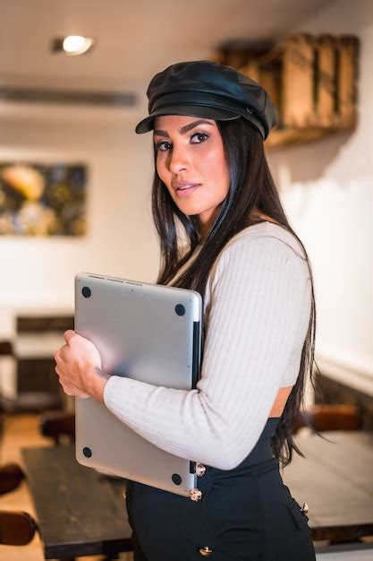 Retrato de uma jovem morena latina um computador teletrabalhando de uma cafeteria nas férias