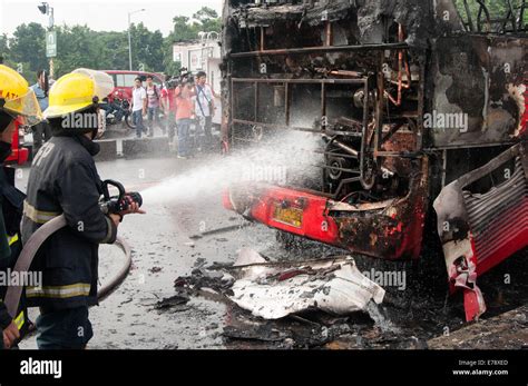 Firefighters Douse Water On The Burned Passenger Bus Along The