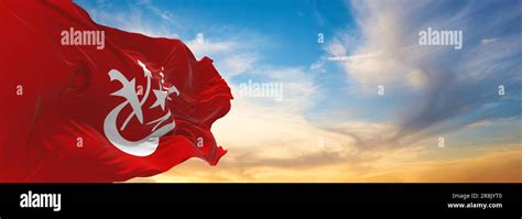 official flag of Kelantan Malaysia at cloudy sky background on sunset ...