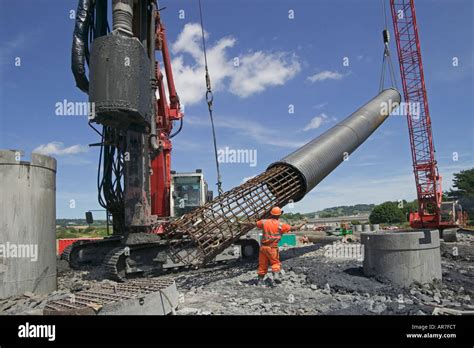 Crane Lifting Steel Reinforced Cage Into An Excavated Pile Concrete