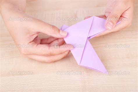 Hands making origami figure, close up Stock Photo by ©belchonock 49775047