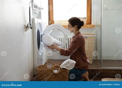 Young Indian Housewife Doing Housework Putting Cloth Into Washing