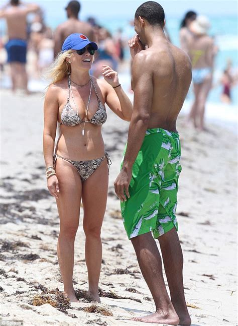 Jill Martin Brings The Miami Heat In A Snakeskin Bikini As She Shares The Beach With Ripped