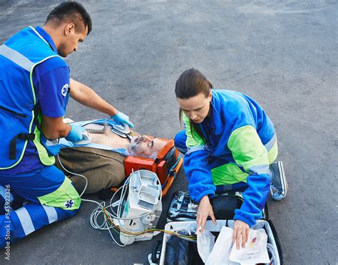 Foto De Paramedics Performing CPR With Mobile Defibrillator For Victim