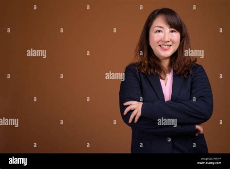 Mature Beautiful Asian Businesswoman Against Brown Background Stock Photo Alamy