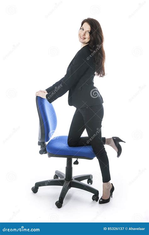 Beautiful Brunette Secretary Poses With One Leg On Office Chair Stock