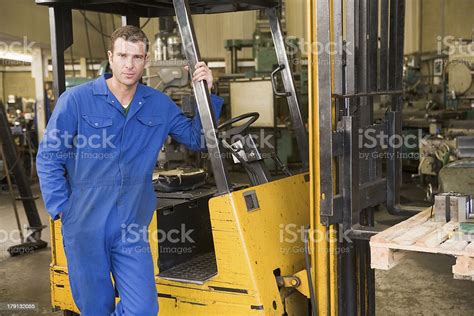 Warehouse Worker Standing By Forklift Stock Photo Download Image Now