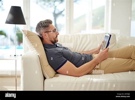 The Smart Way To Spend A Leave Day A Handsome Mature Man Relaxing On The Sofa At Home Stock