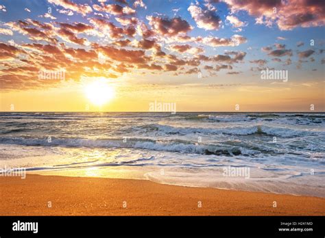 Colorful Ocean Beach Sunrise With Deep Blue Sky And Sun Rays Stock