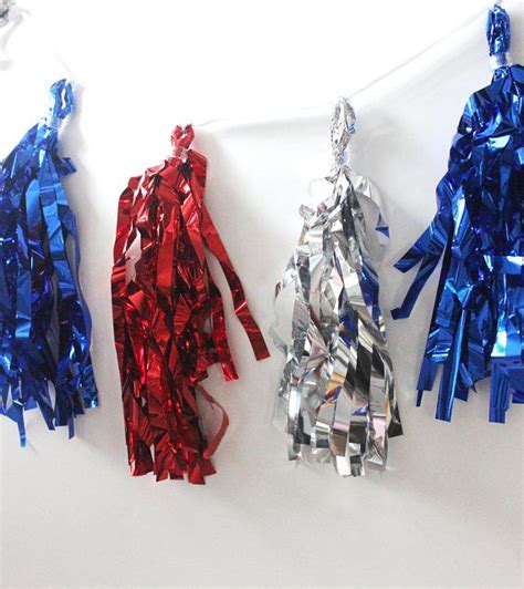 Three Different Colored Ribbons Are Hanging On A White Wall One Is Red