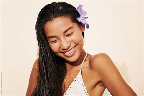 Woman Smiling Eyes Closed With Flower By Stocksy Contributor