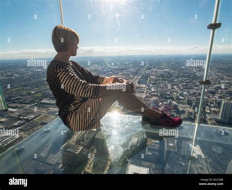 Tourists posing on a glass floor Stock Photo - Alamy