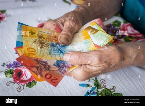 Rentnerin hält eine Banknote mit niedrigem Nennwert in ihren Händen