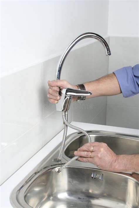 Installing a Faucet in a Stainless Steel Kitchen Sink Stock Image ...