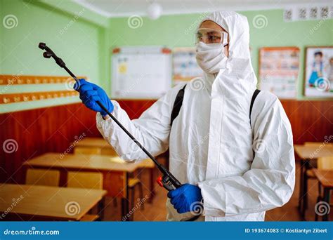 Close Up Of A Man Wearing A Disinfection Protective Suit Cleans The