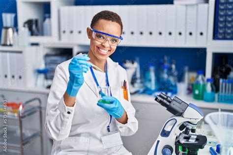 African American Woman Scientist Smiling Confident Pouring Liquid On