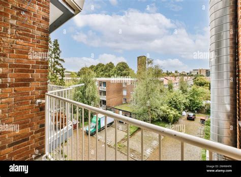 a balcony with brick walls and white railings, looking out onto the ...