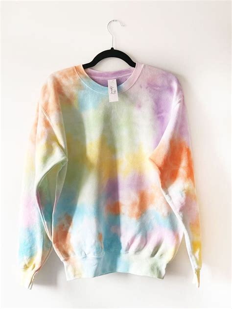 A Tie Dye Sweater Hanging On A Hanger