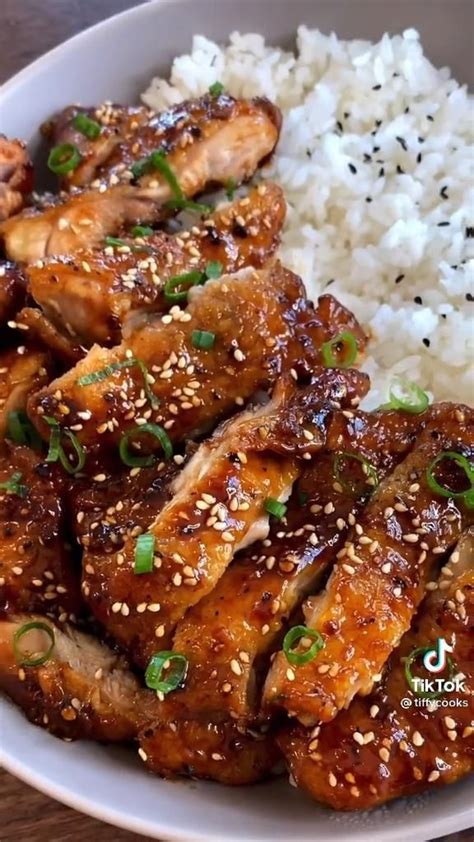 A White Plate Topped With Chicken And Rice