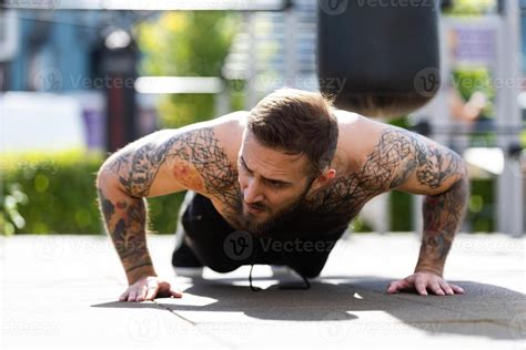 Muscular Bodybuilder Handsome Man With Naked Torso Trains Triceps In A Crossover Cable Exercise