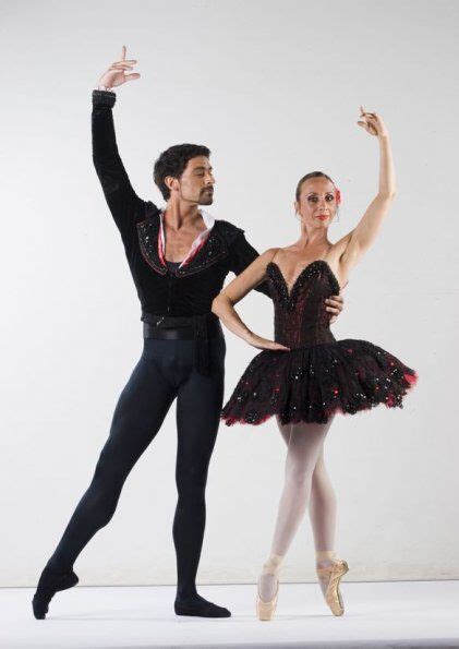 Two Ballerinas In Black And Pink Tutus Pose For The Camera While One Holds Her Leg Up